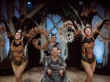 A young man and woman dressed as a kangaroos, standing next to two female dancers wearing elaborate, sparkly costumes.